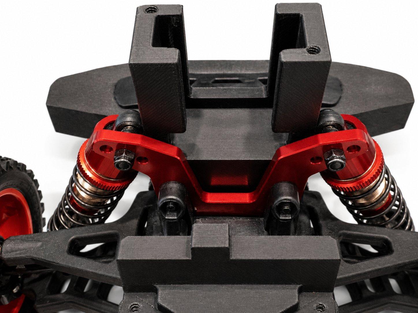 The front bumper and printed upper bracket seated over the red front shock tower