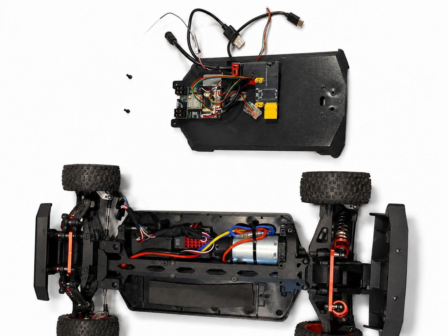 The printed mid section with its orange battery lid held above the chassis