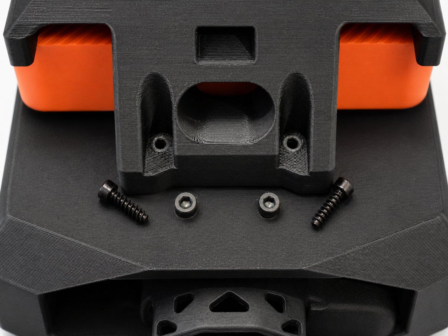 The two screws and washers that fasten the top layer to the lower printed section