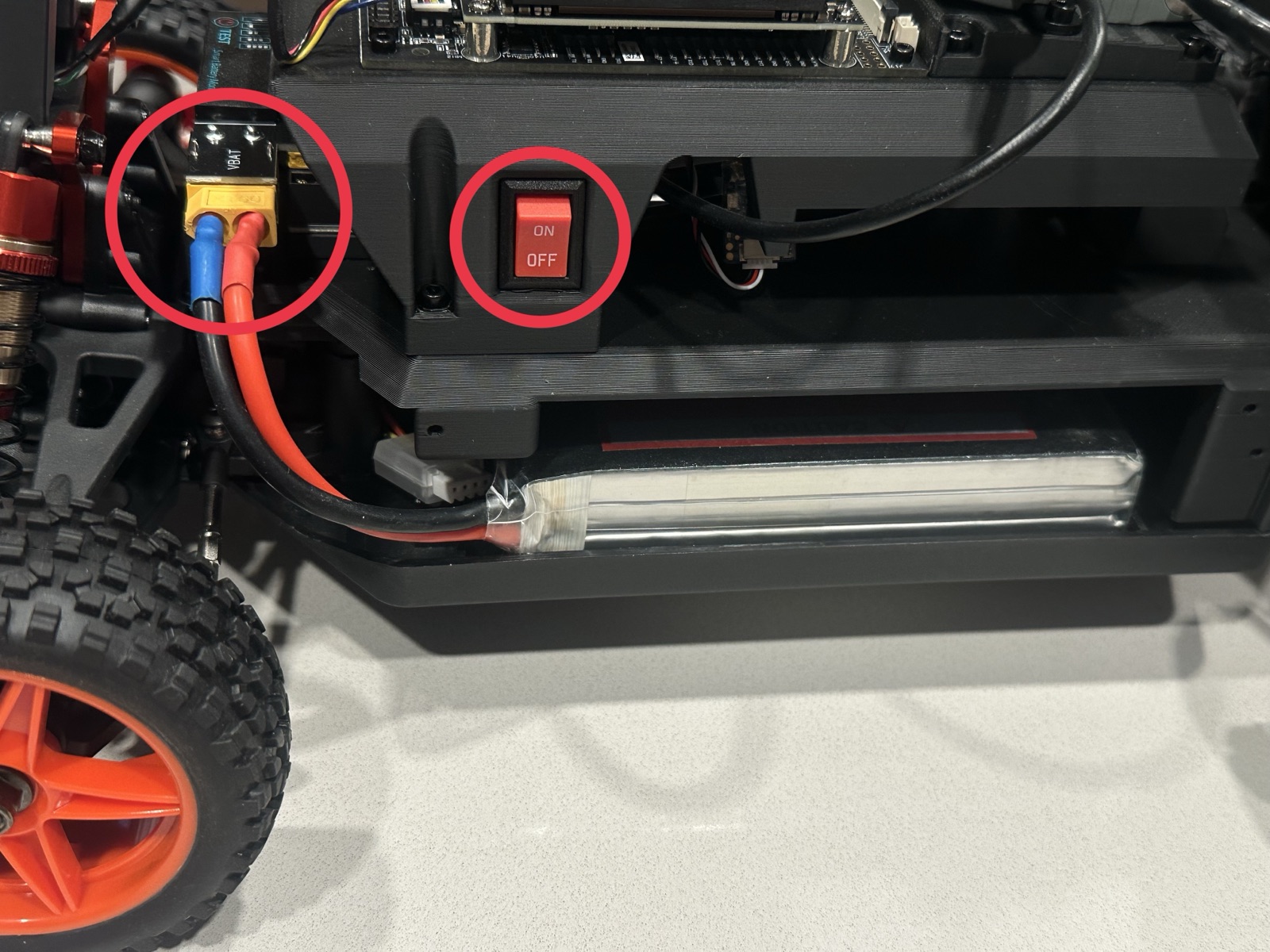 Click to enlarge The battery in its tray on the left side of the car, with the XT60 connector and power switch highlighted
